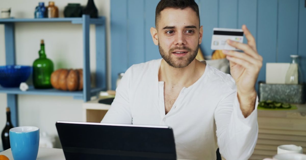 Um ecrã de computador exibe um website de e-commerce com a bandeira de Portugal no canto superior e a extensão de domínio .pt visível, simbolizando a confiança e a relevância local. Ao lado, um smartphone e um cartão de crédito.