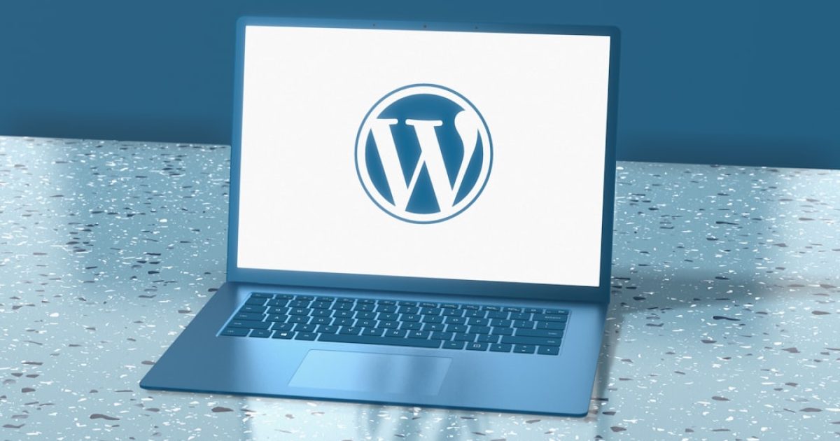 Mãos a trabalhar num teclado de computador, com ecrã a mostrar código e o logótipo do WordPress, simbolizando a gestão de atualizações cruciais.